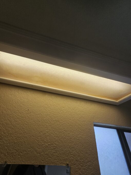 Old lighting with broken covers and mismatched bulb